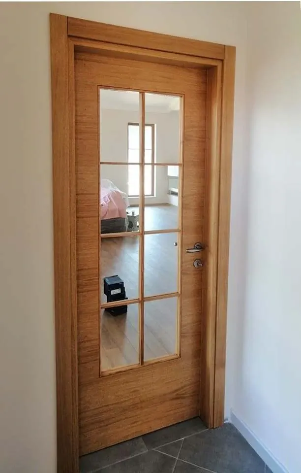 Installed wooden door with eight glass panes in a bright hallway