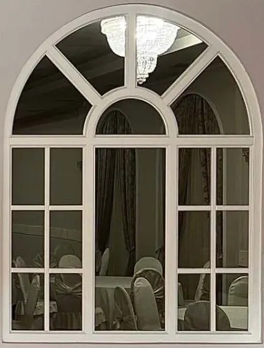 White arched interior window with a semicircular head, inner arch and small clear lites, right of the entrance