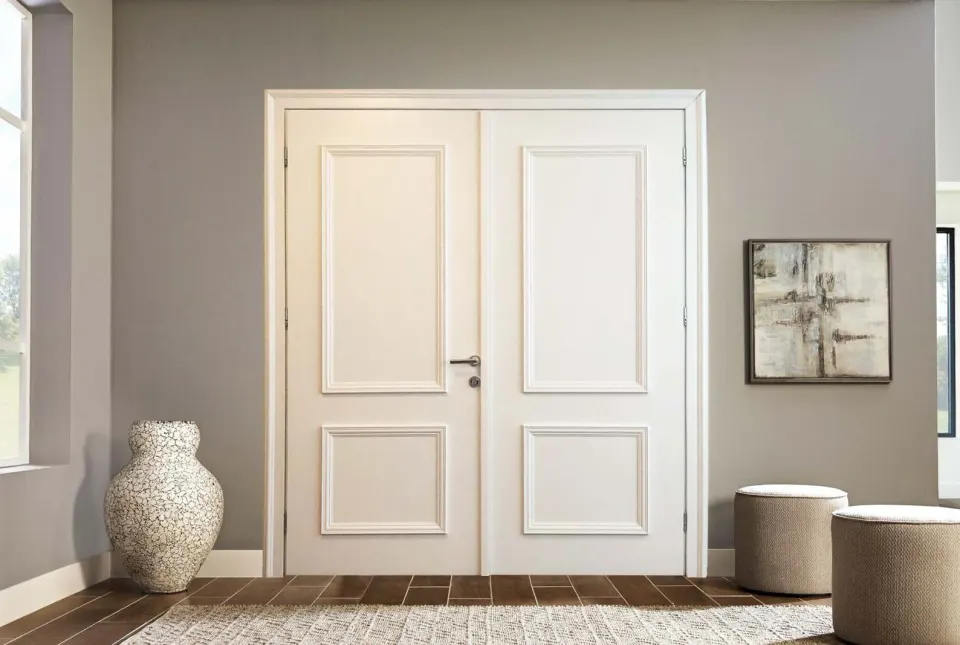 White double door with two panels per leaf beside a vase and stools
