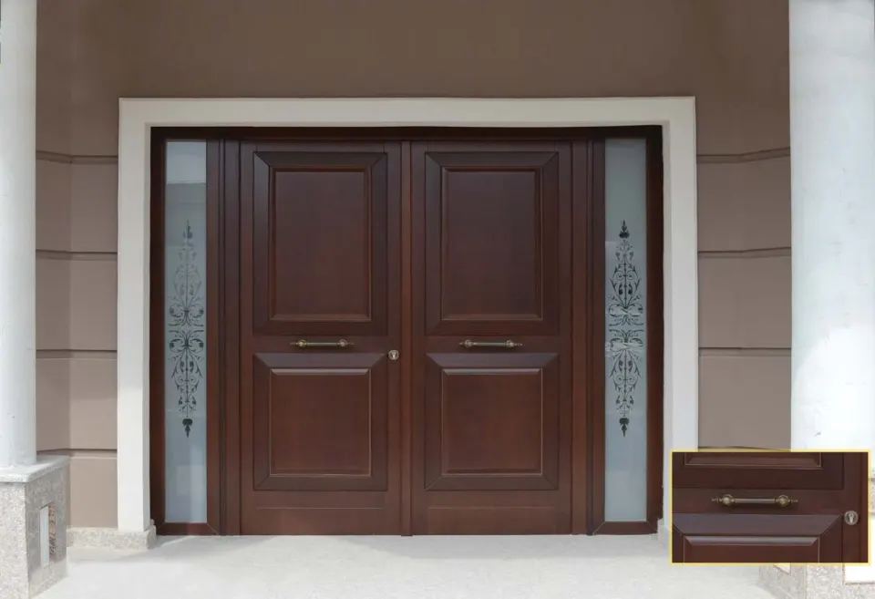 Dark exterior double door with ornamented glass side lights and a handle detail