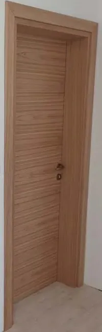 Second flush door in horizontal-grain veneer in the same hallway, seen at an angle