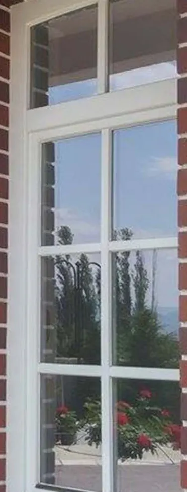 White wooden window with a two-pane top light and six lites in a red-brick wall